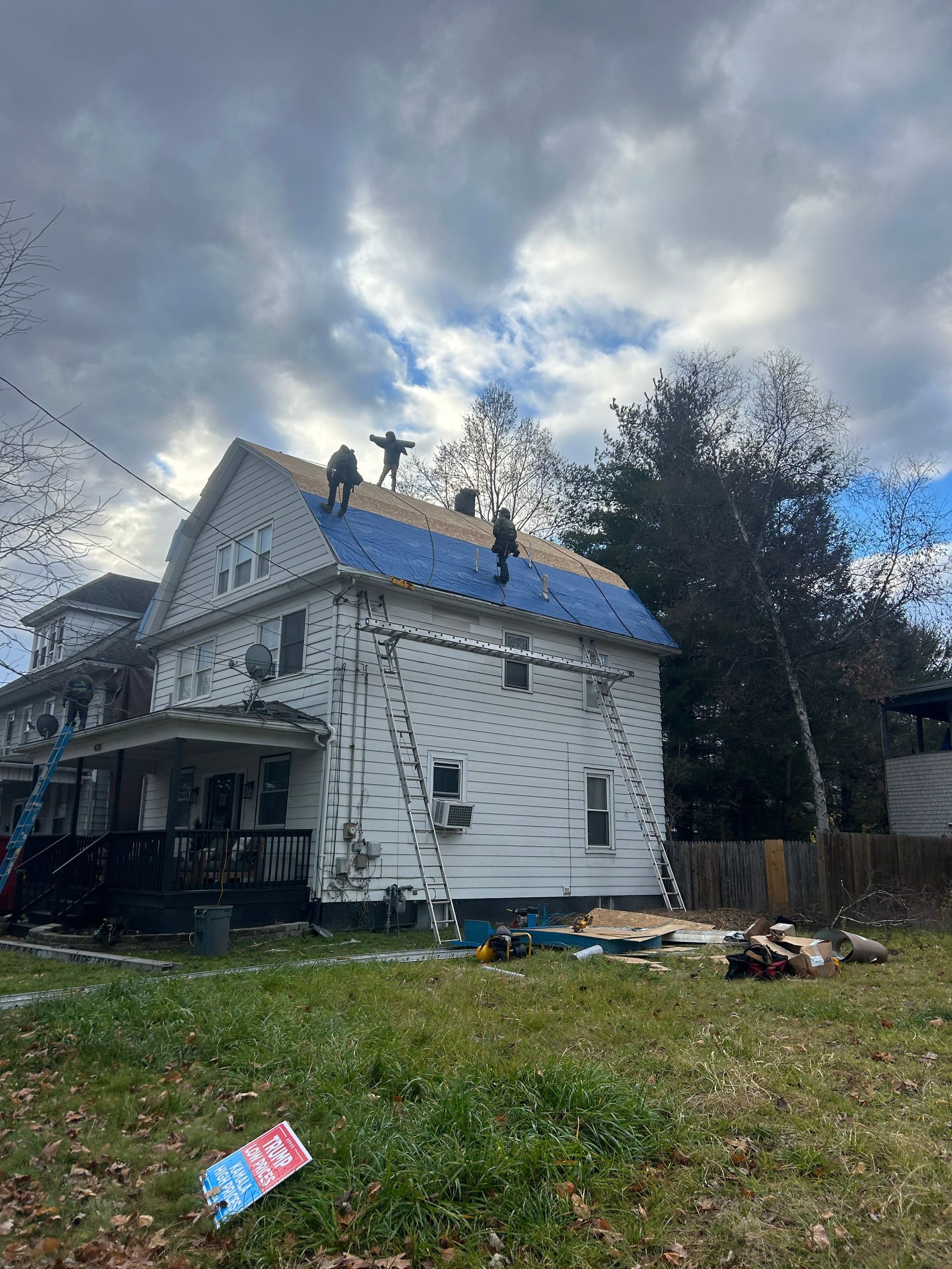 A white house with a blue roof is being remodeled