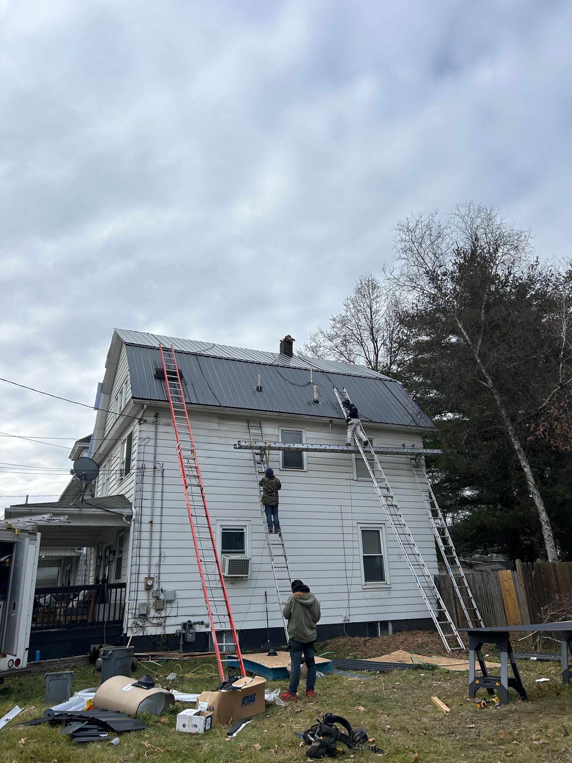 A group of people are working on the roof of a house