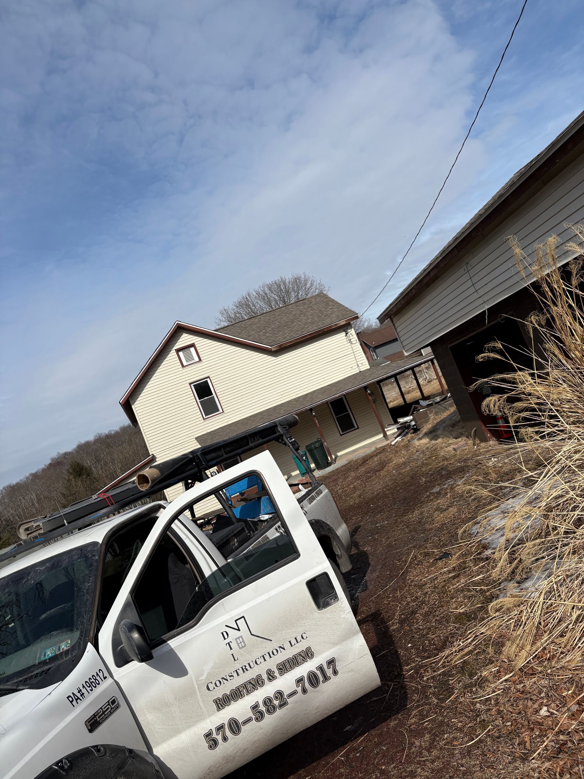 A white truck is parked in front of a house.