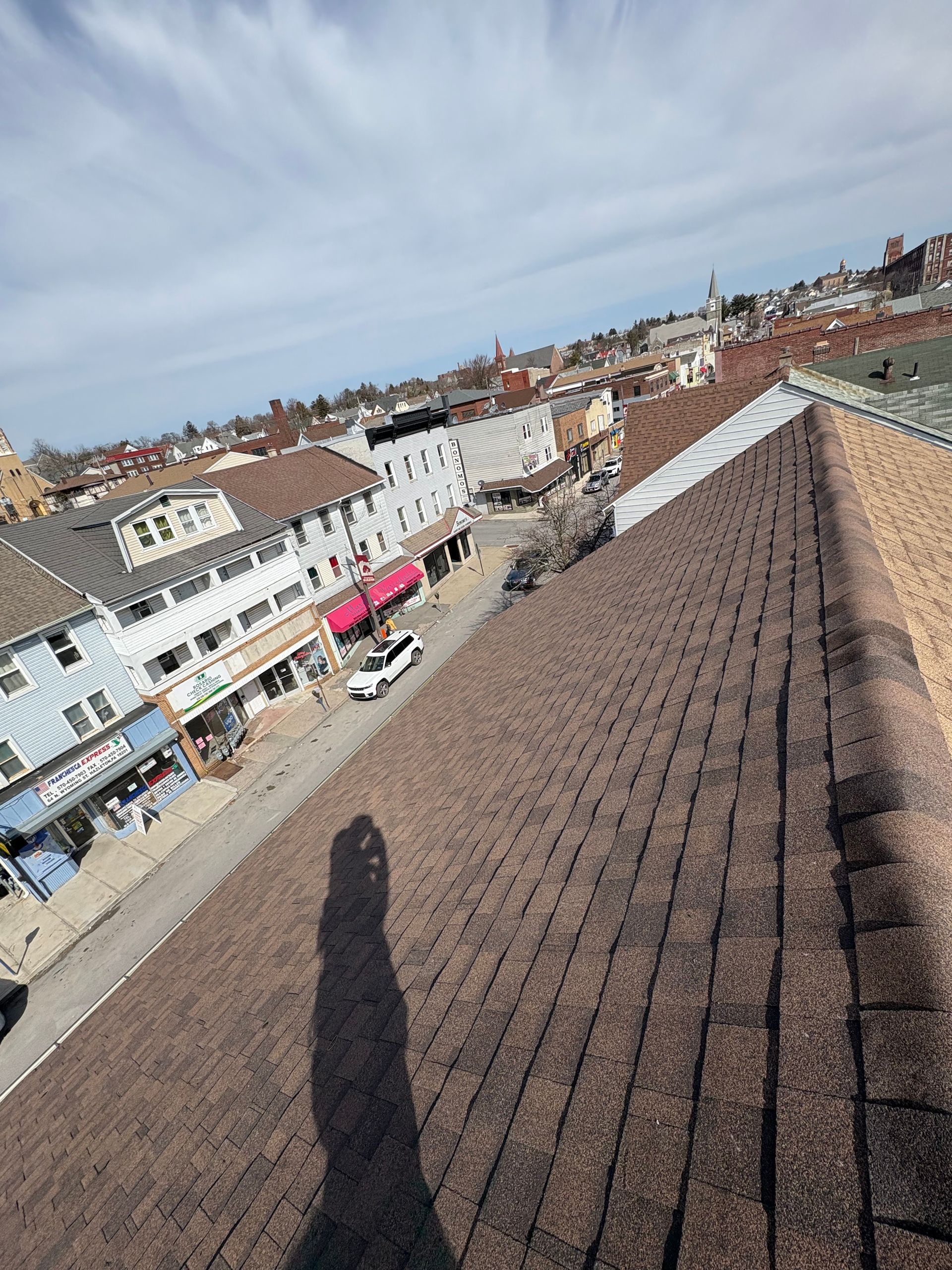 A shadow of a person is cast on the roof of a building