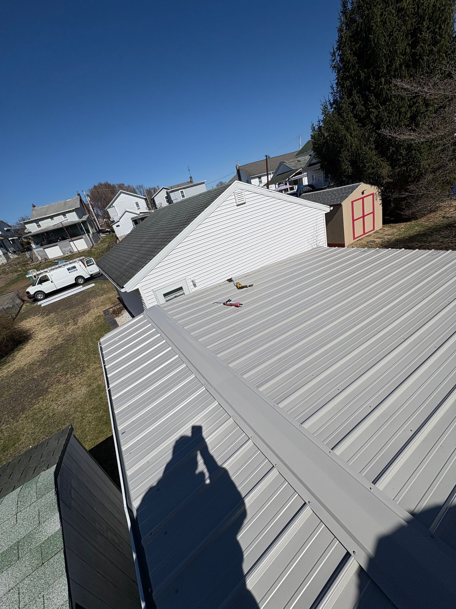 A shadow of a person is cast on the roof of a house