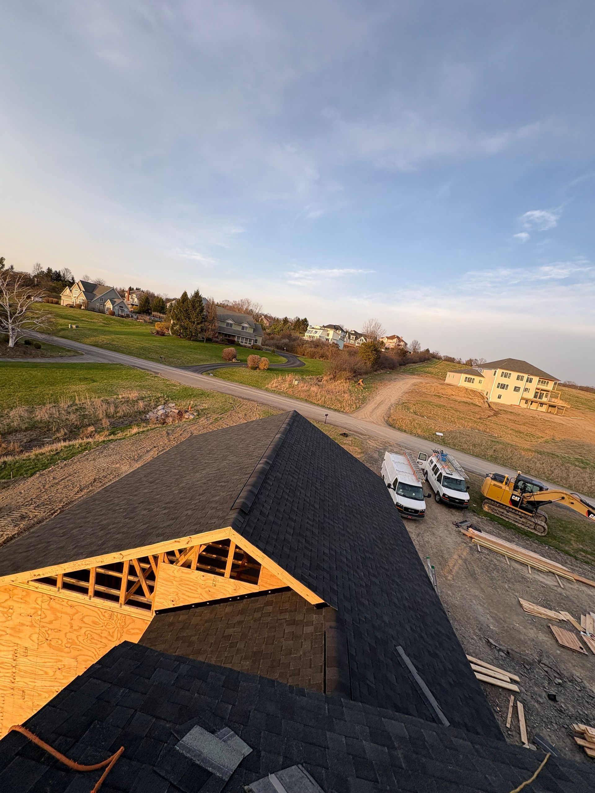An aerial view of a house under construction with a roof being installed