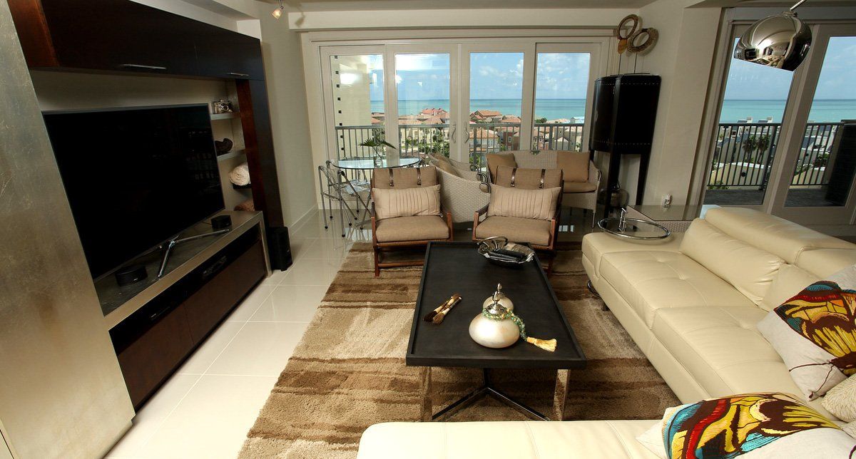 Una sala de estar con un sofá, sillas y un televisor de pantalla plana.