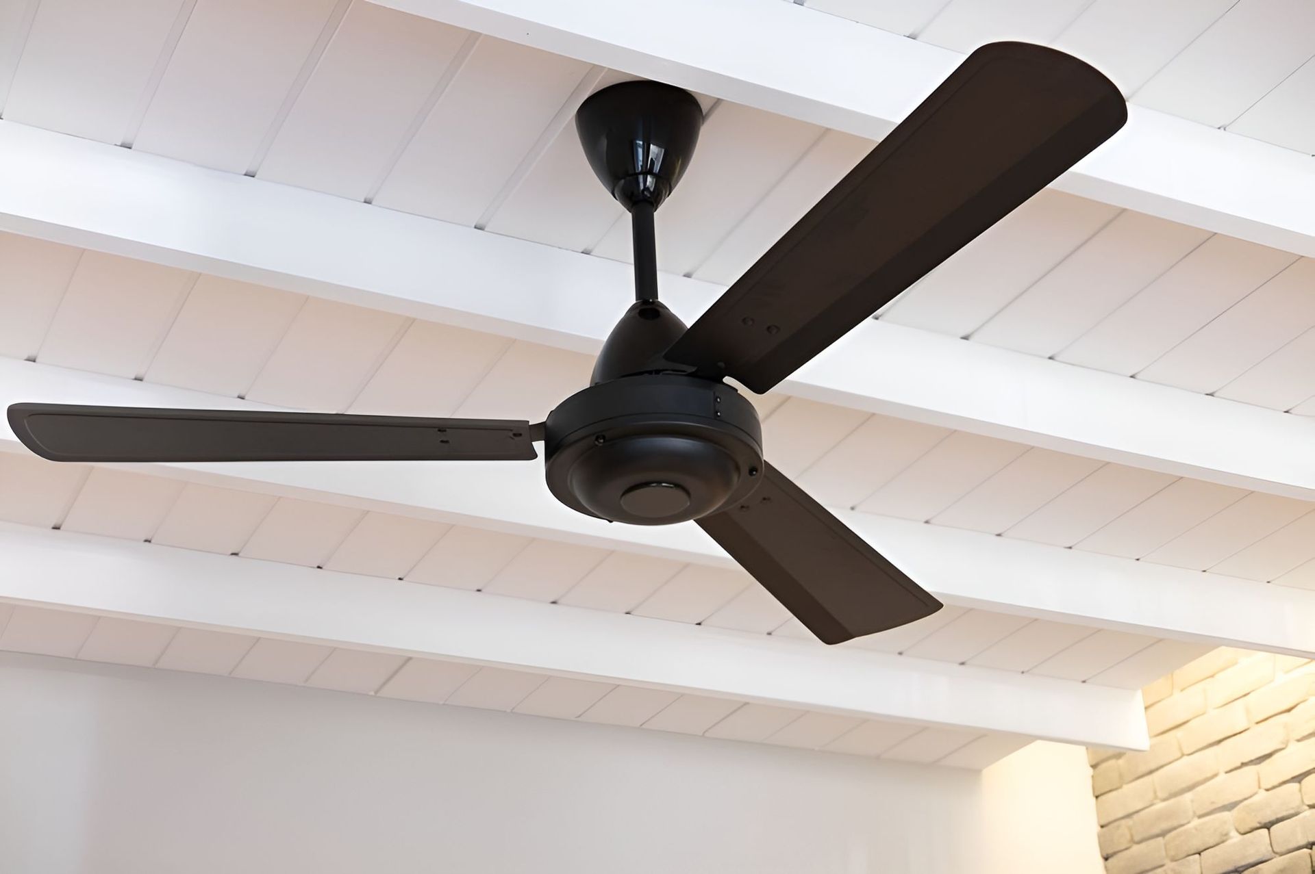 A Black Ceiling Fan is Hanging From a White Ceiling — Our Sparky In Urraween, QLD
