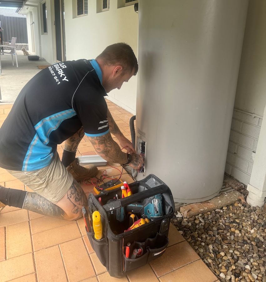 Man Repairing Electrical Hot Water System — Our Sparky In Urraween, QLD