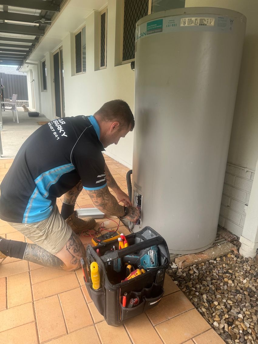 A Man Repairing A Hot Water System — Our Sparky In Urraween, QLD