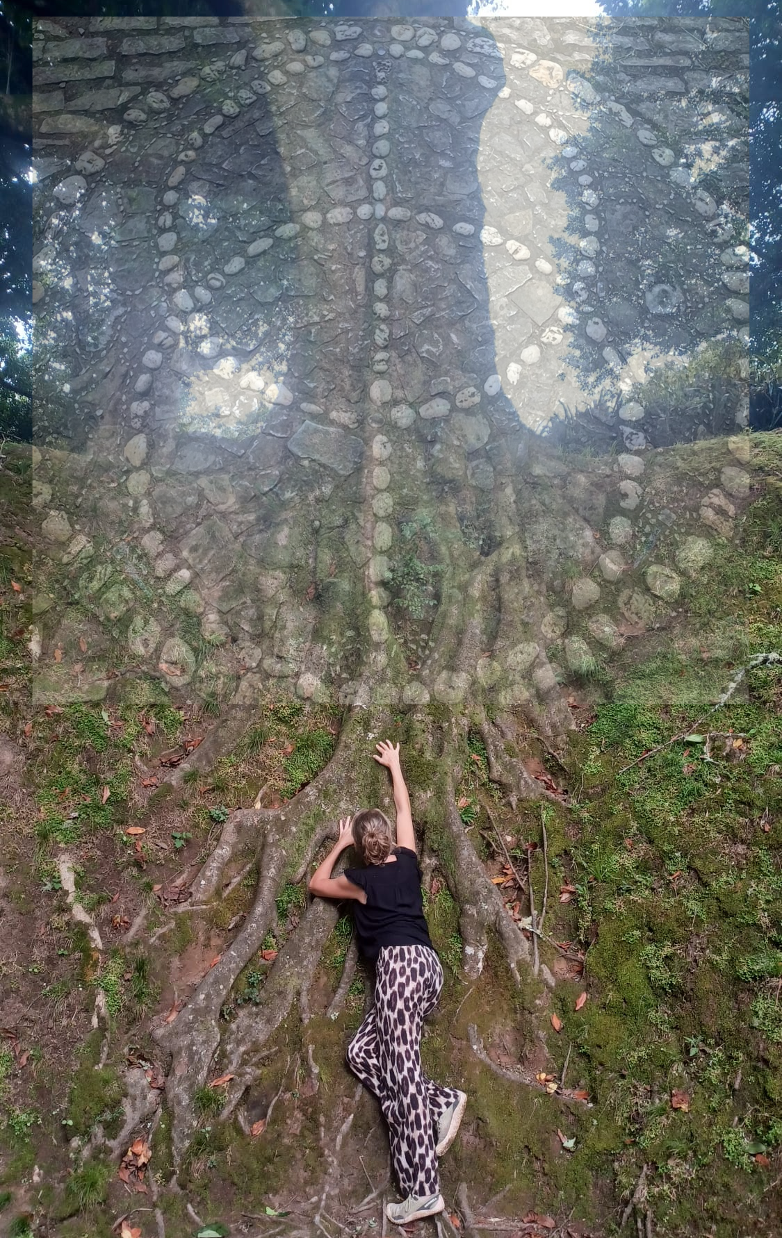 Vrouw ligt bij boomwortels en reikt omhoog naar een ingewikkeld stenen ontwerp erboven. Boslandschap, zonlicht.