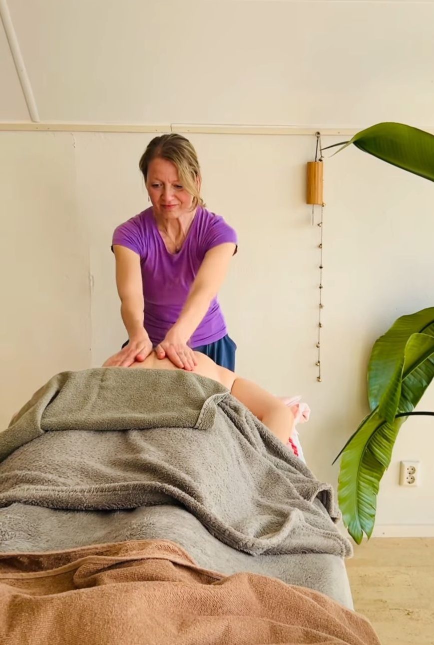 vrouw masseert persoon op tafel