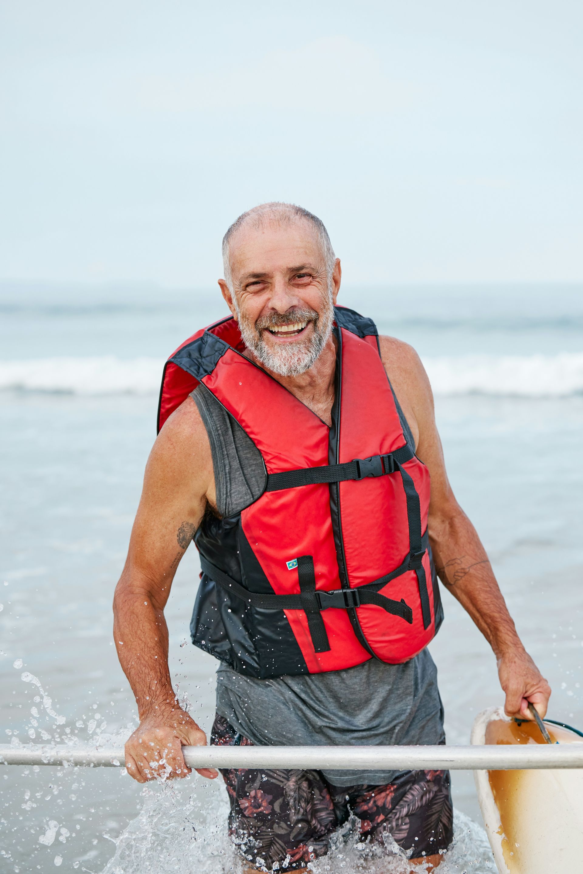 A man in a life jacket is standing on a boat in the ocean.