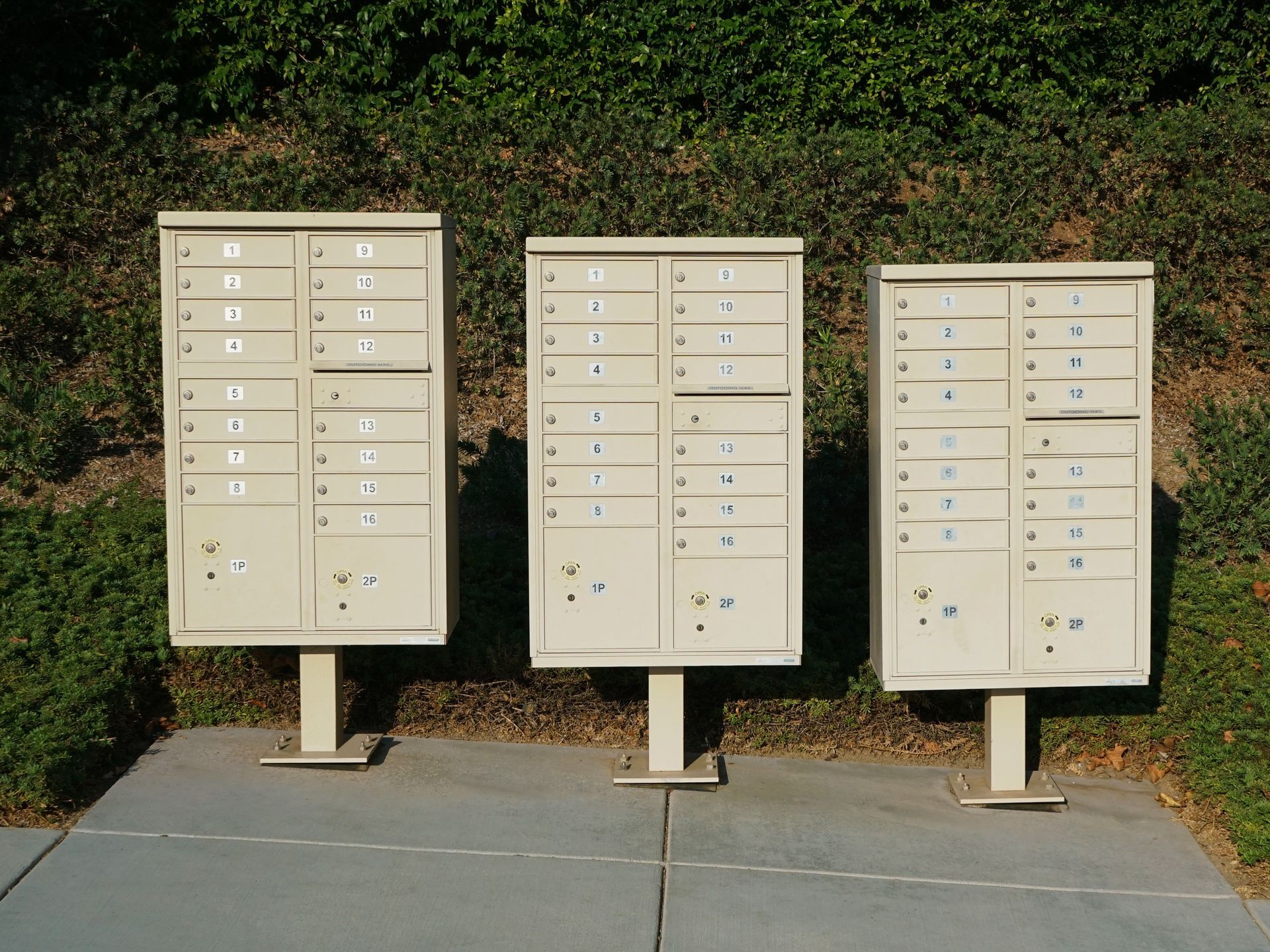 three mailboxes are lined up in a row on a sidewalk