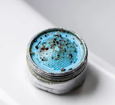 A close up of a faucet filter on a sink.