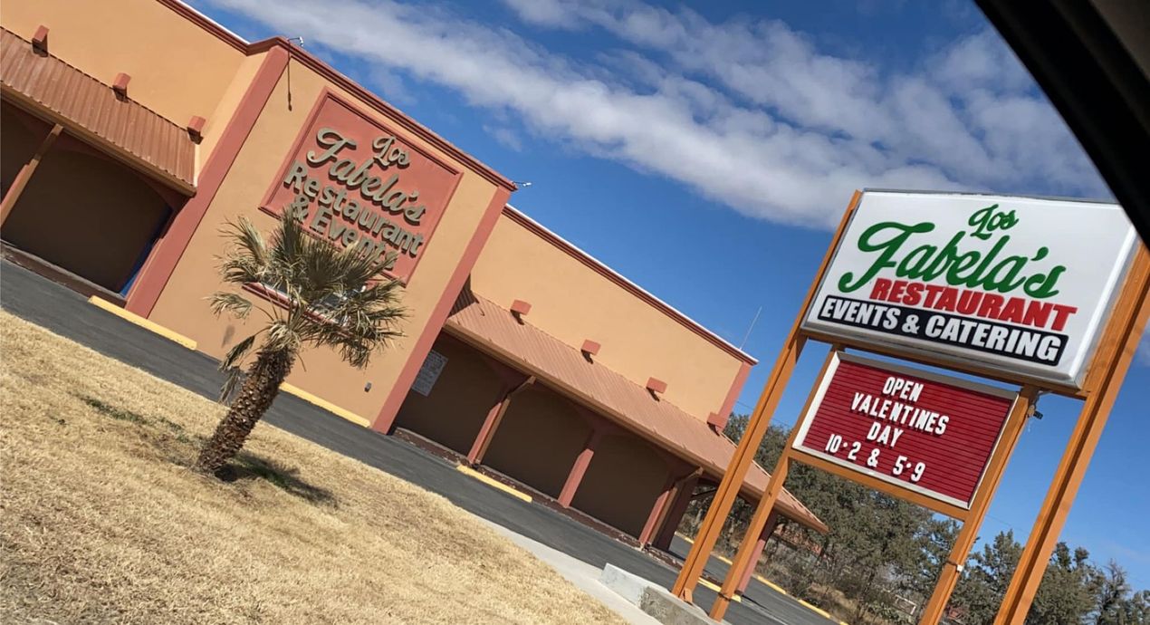 A tan, single-story restaurant building with a large sign reading 