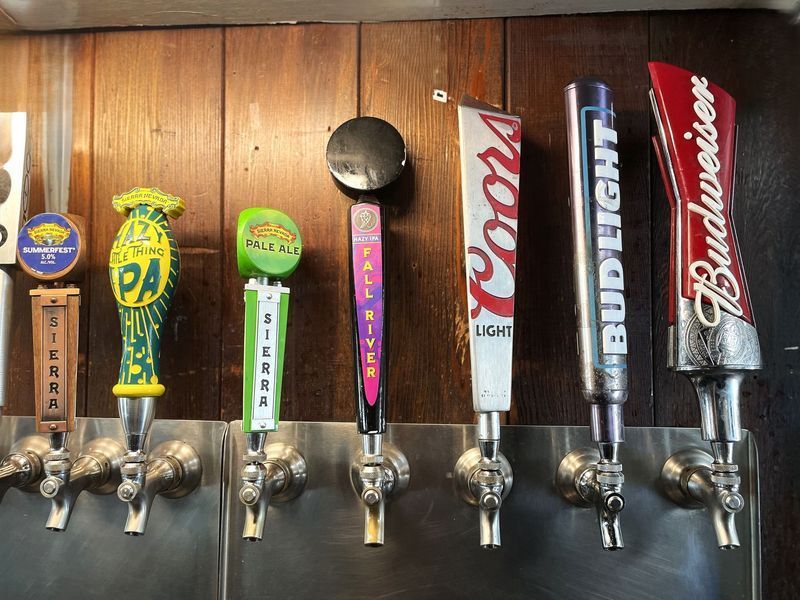 Beer taps with colorful brand handles. Includes Sierra Nevada, Coors Light, and Budweiser.