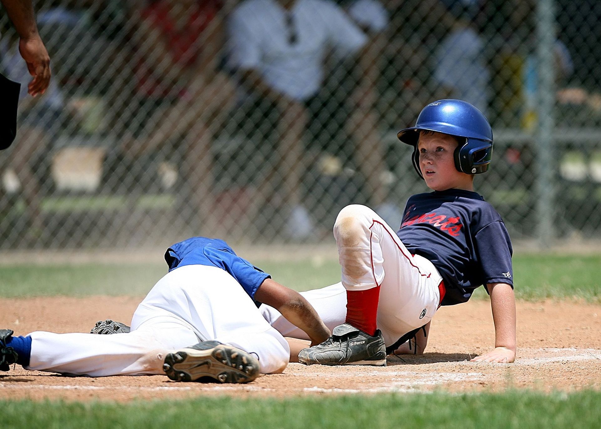 Baseball player sliding into base as another player attempts to catch the ball.