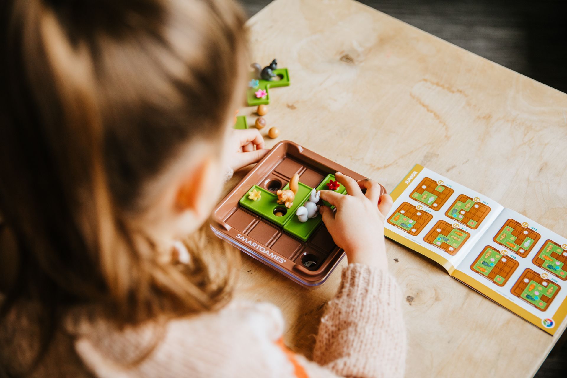 Criança jogando jogo de lógica Squirrels Go Nuts da SmartGames