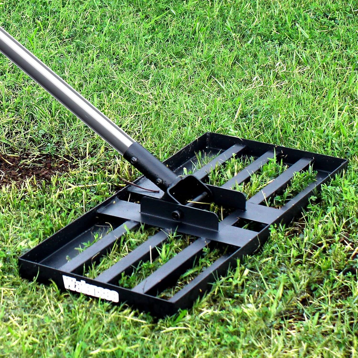 Black lawn leveler on green grass