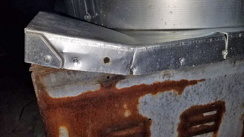 A rusty metal object is sitting on top of a concrete block.