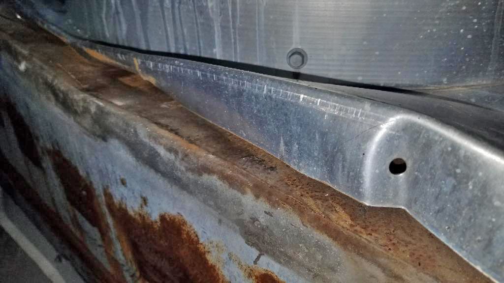 A close up of a rusty metal surface with a hole in it.