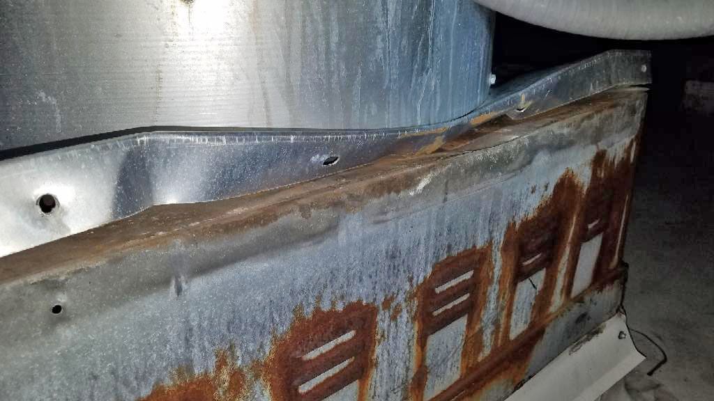 A close up of a rusty metal object in a dark room.