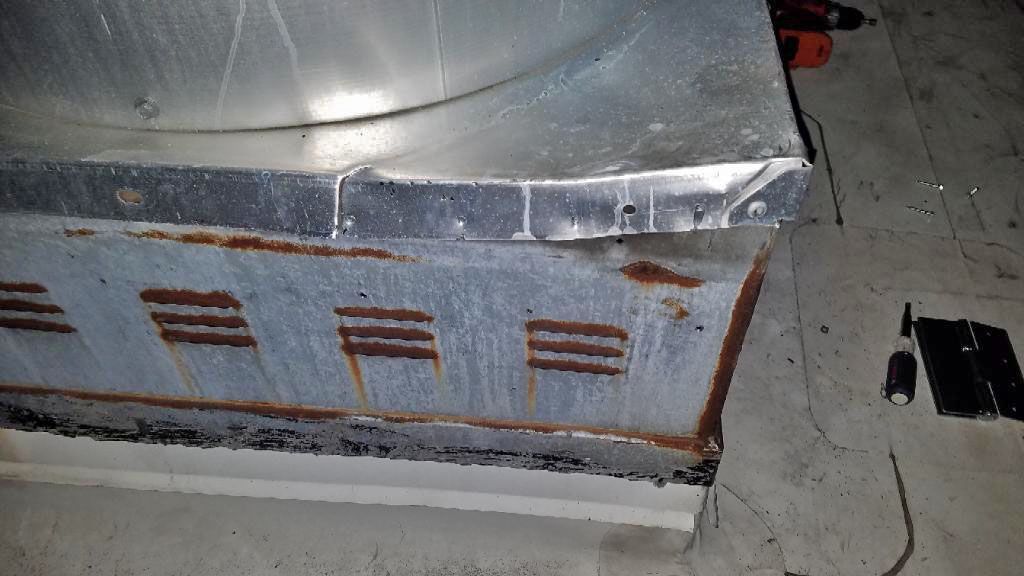 A rusty metal box is sitting on a concrete floor.