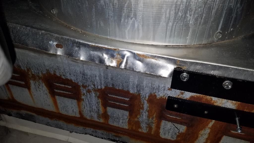 A close up of a rusty metal surface with a hole in it.