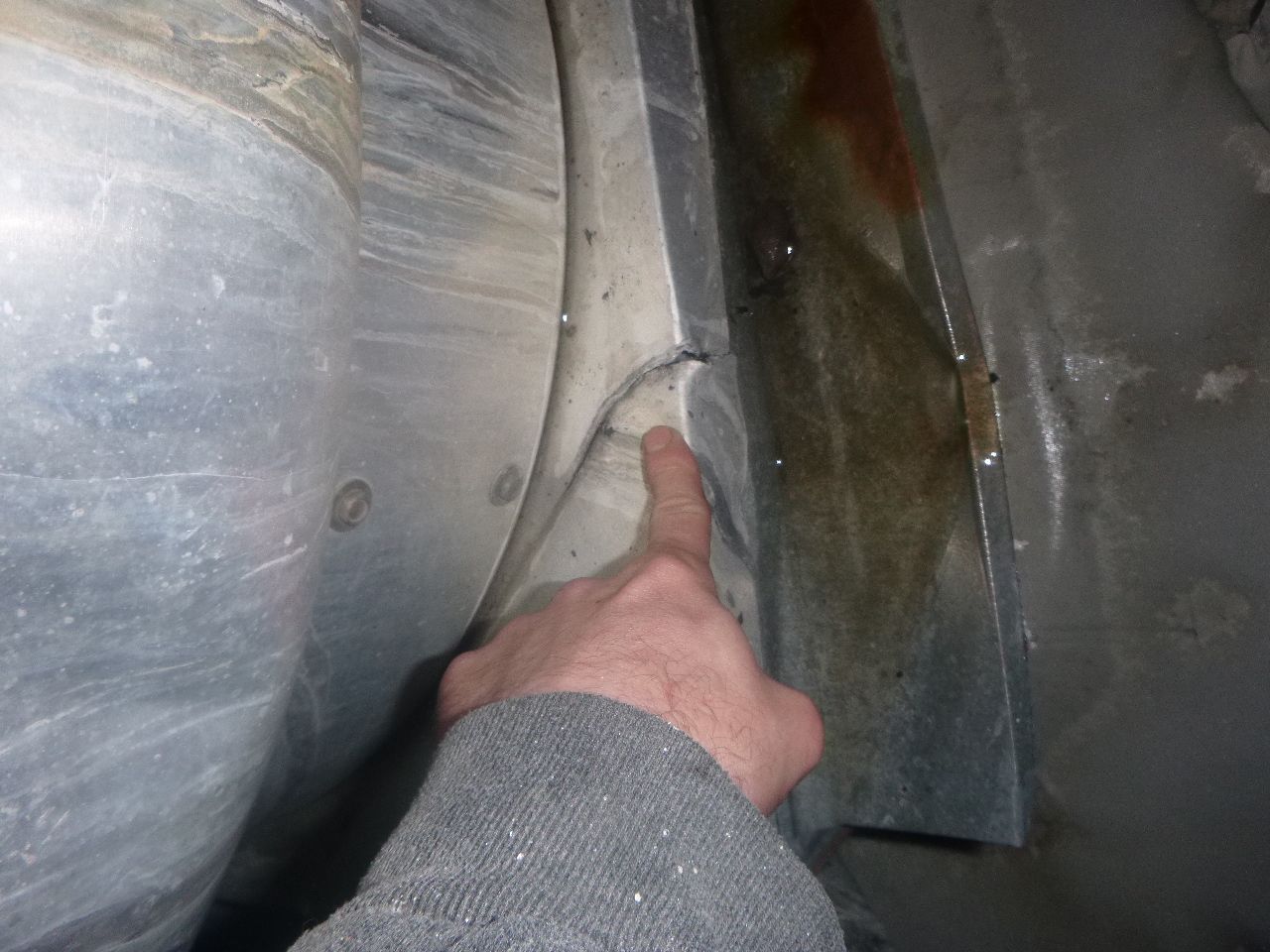 A person is pointing at a piece of metal with their finger.