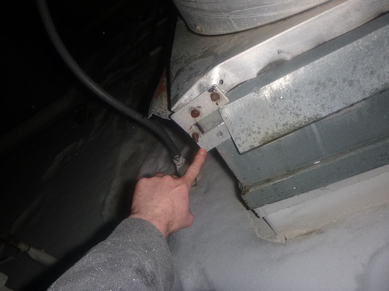 A person pointing out at a piece of metal