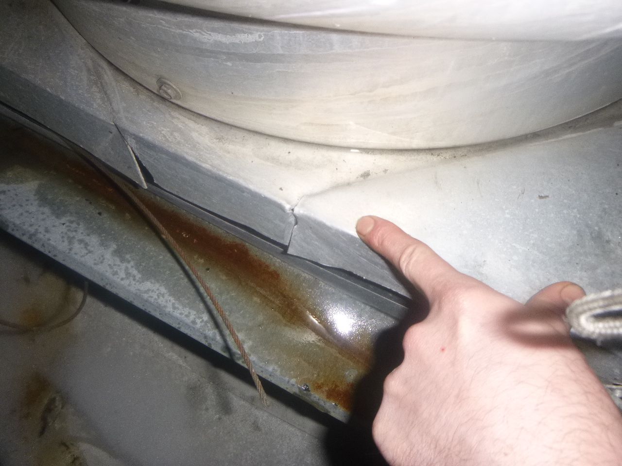 A person is pointing at a piece of metal.