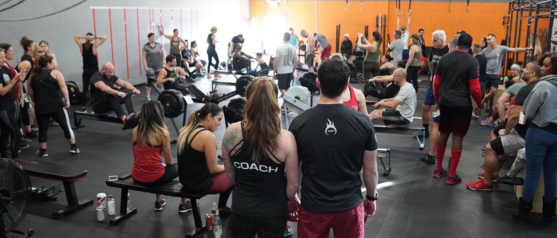 A large group of people are standing in a gym.
