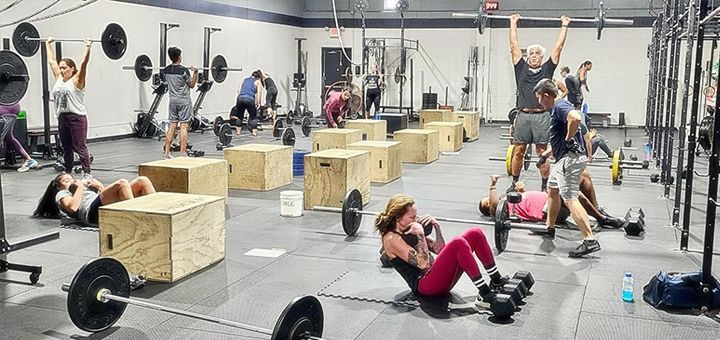 A group of people are doing exercises in a gym.