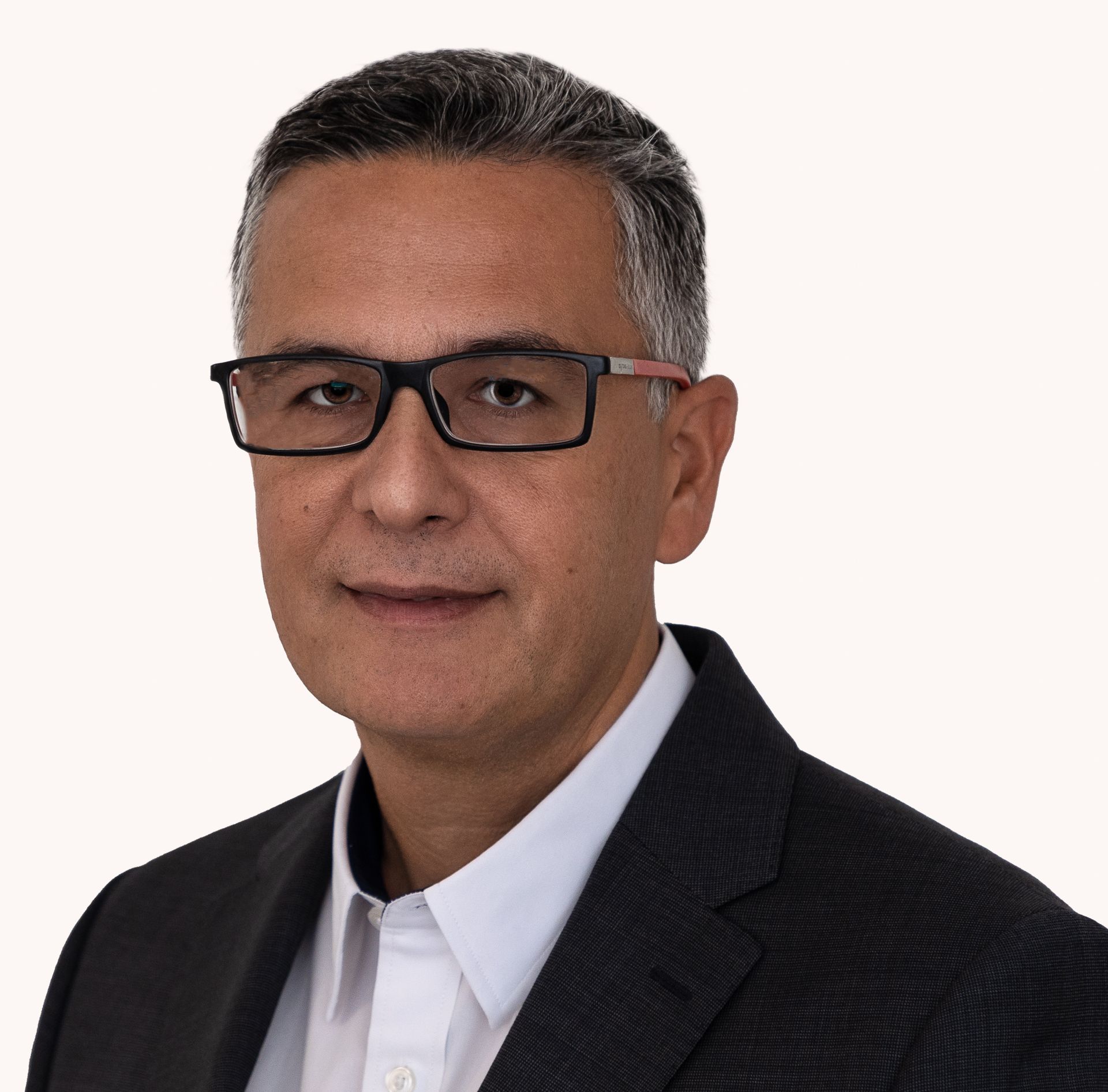 Man wearing glasses and suit smiling at the camera.