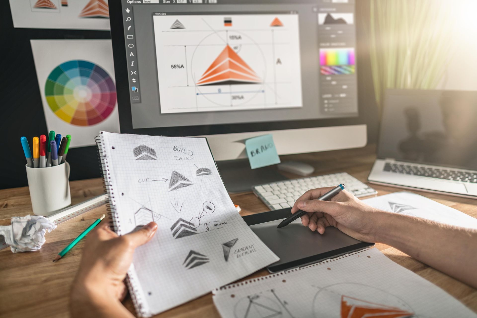 Designer working on logo designs at a desk.