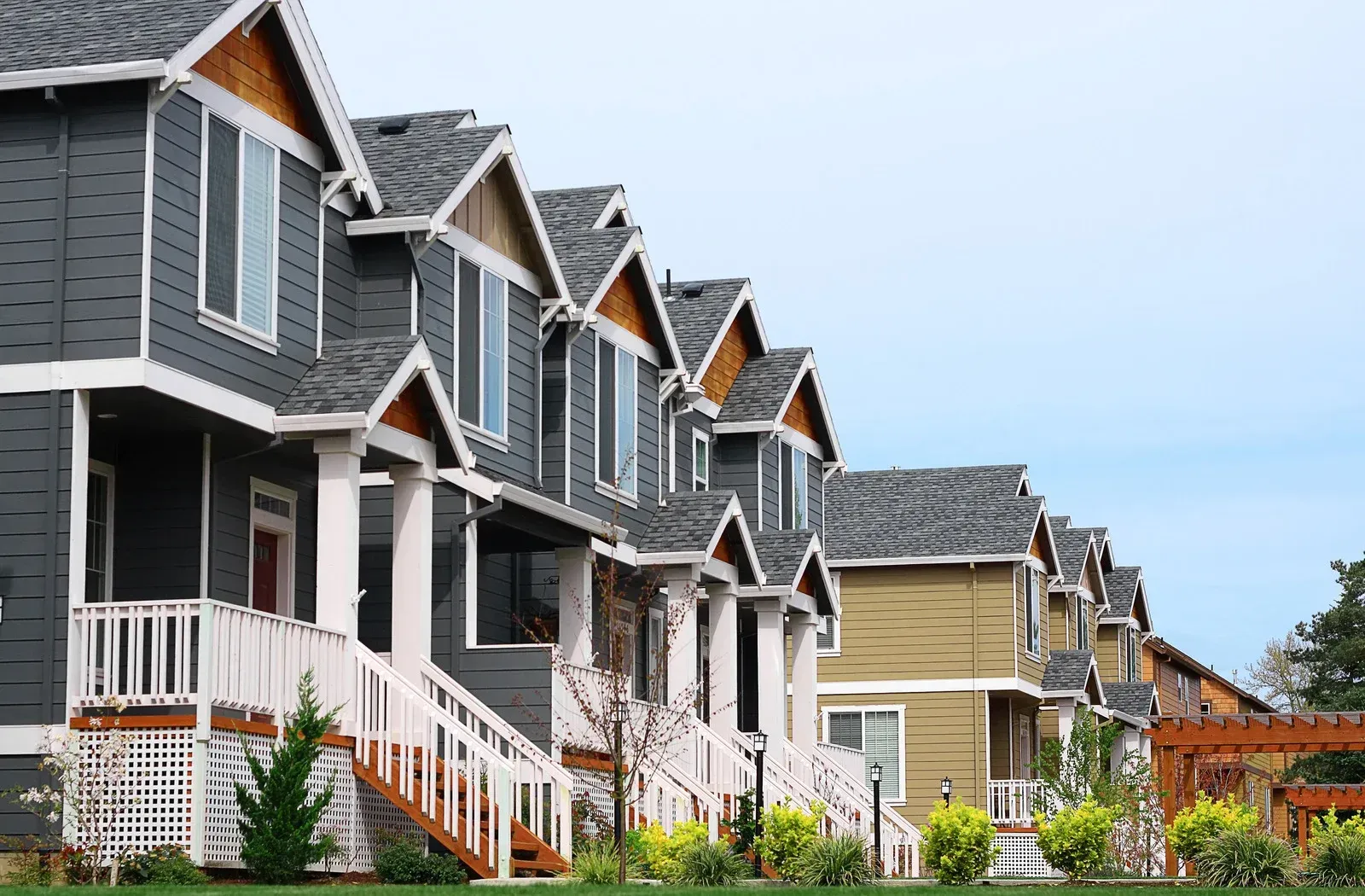 A row of houses in a residential area with a blue sky in the background.