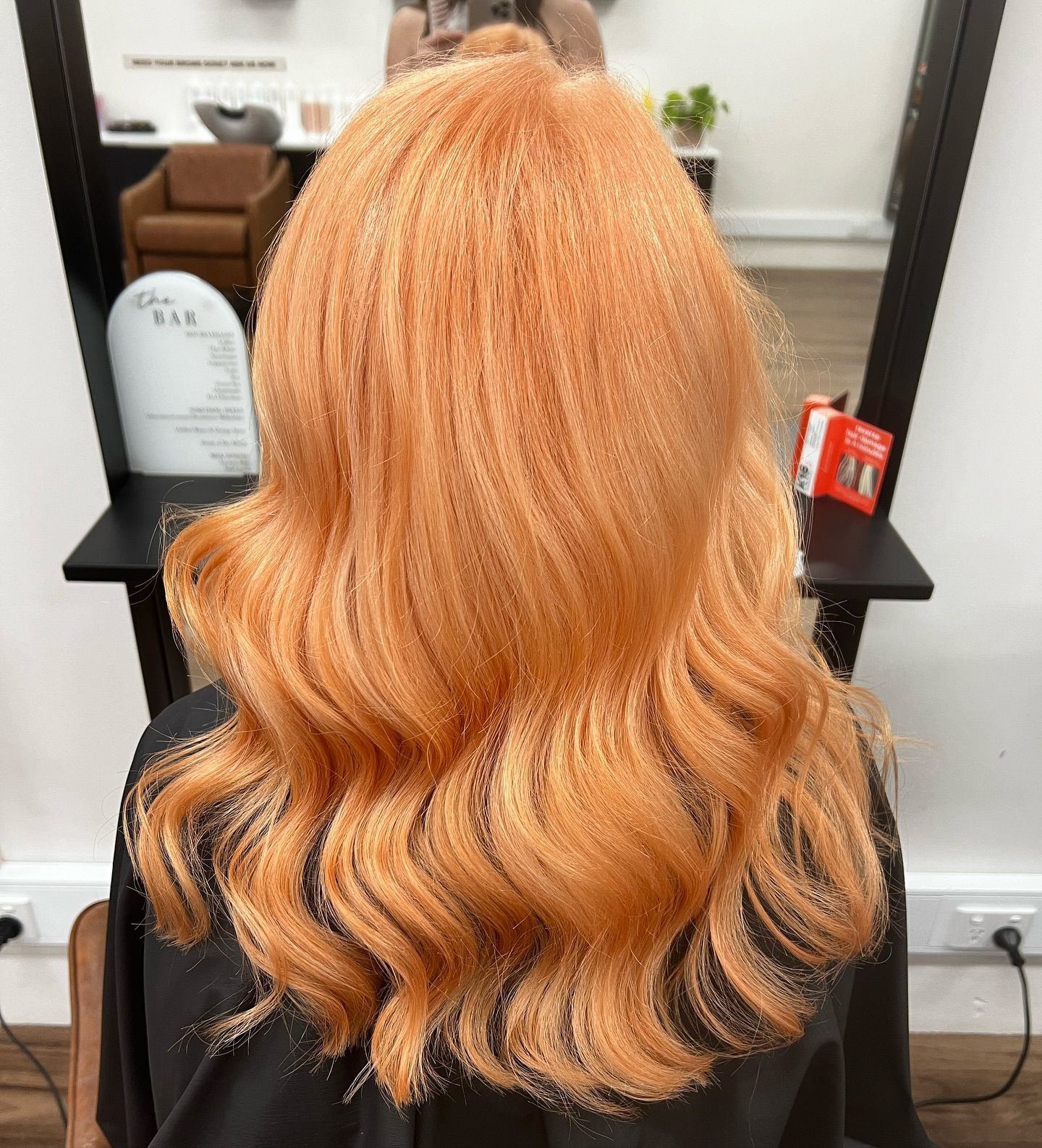 A woman with orange hair is sitting in a chair in front of a mirror. — Mysa on Flinders In Townsville City, QLD