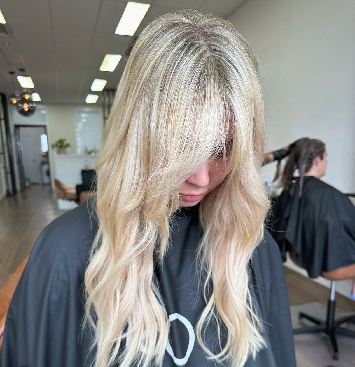 A woman with blonde hair is wearing a black cape — Mysa on Flinders In Townsville City, QLD