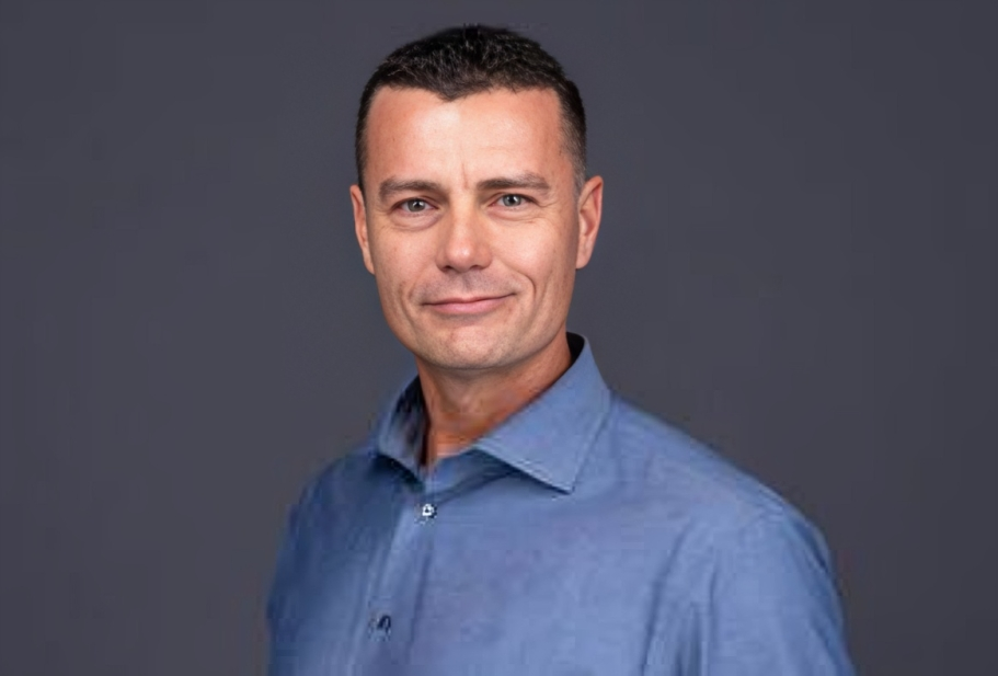 Bill Schauman Personal Injury Lawyer CA Portrait of a man in a blue shirt against a dark gray background