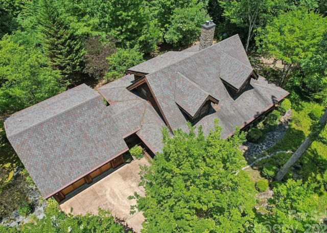 House under construction with workers, blue sky with clouds.