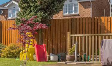 There is a wooden fence in the backyard of a house.