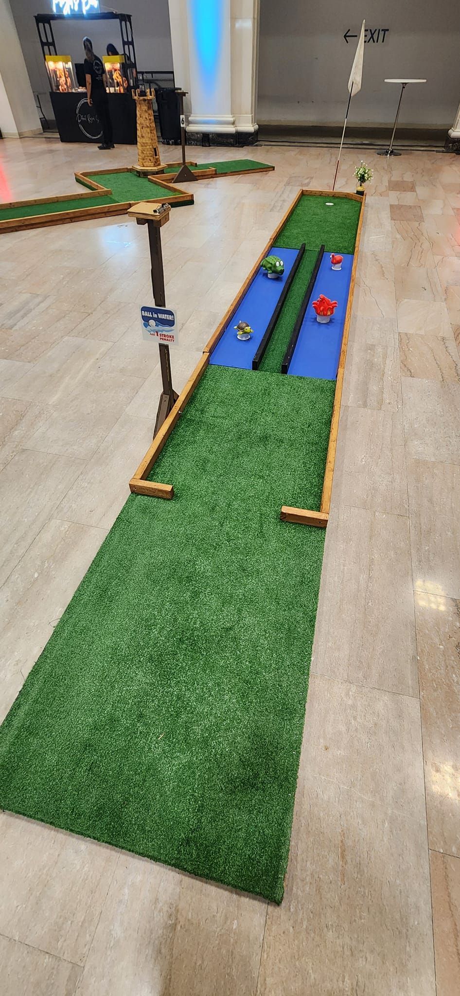 Mini golf course indoors with green and blue turf.