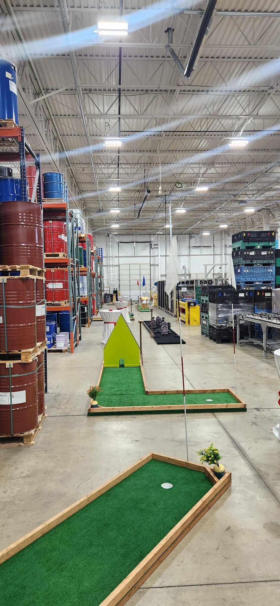 Mini golf course set up in an industrial warehouse.