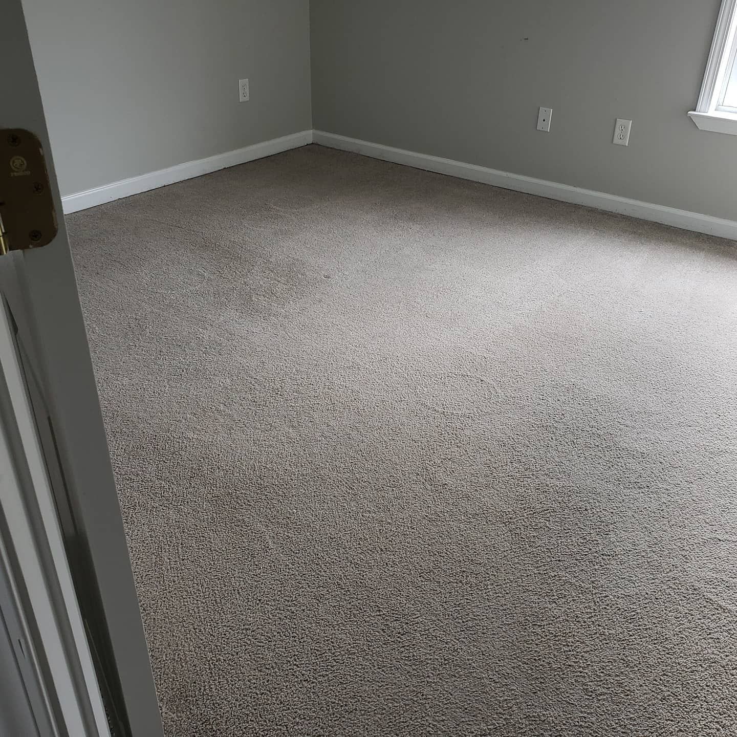 A room with a carpeted floor and gray walls.