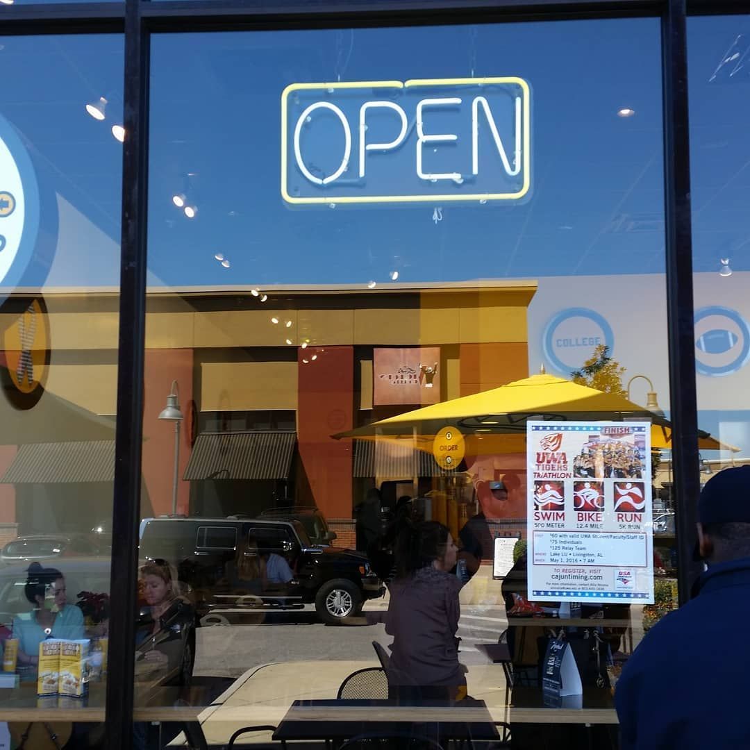 An open sign is lit up in the window of a restaurant