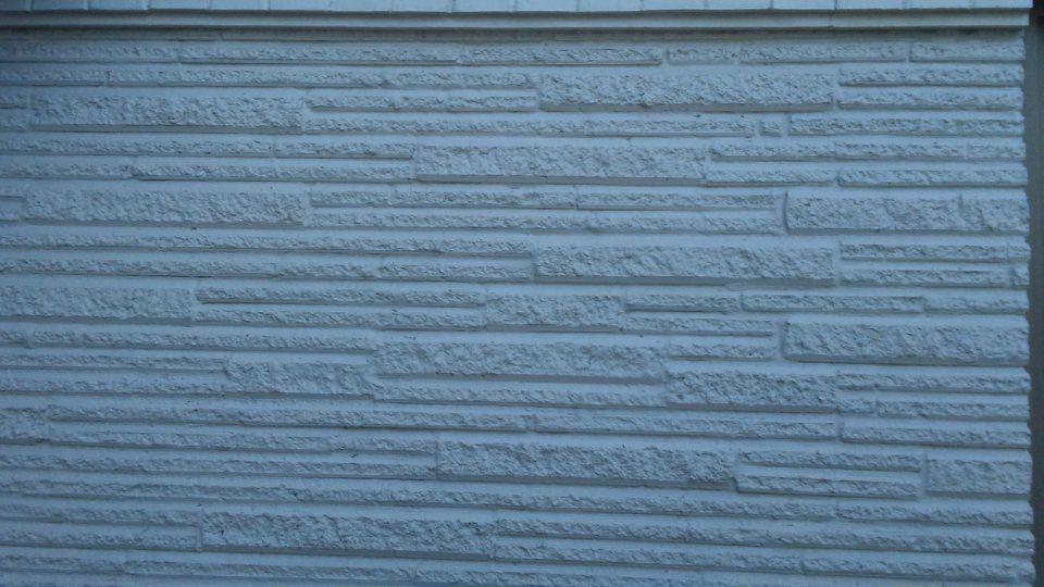 Textured, light-blue exterior wall with horizontal, uneven ridges.