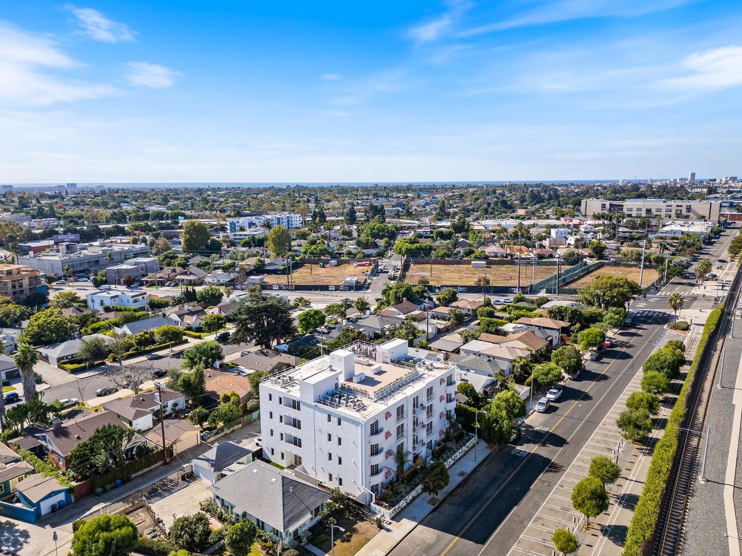 An aerial view of a city with a white building in the middle of it.