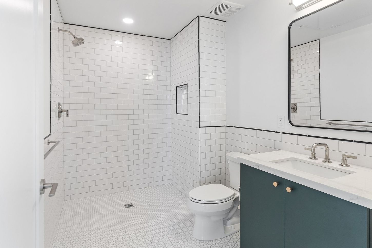 A bathroom with a toilet , sink and shower.