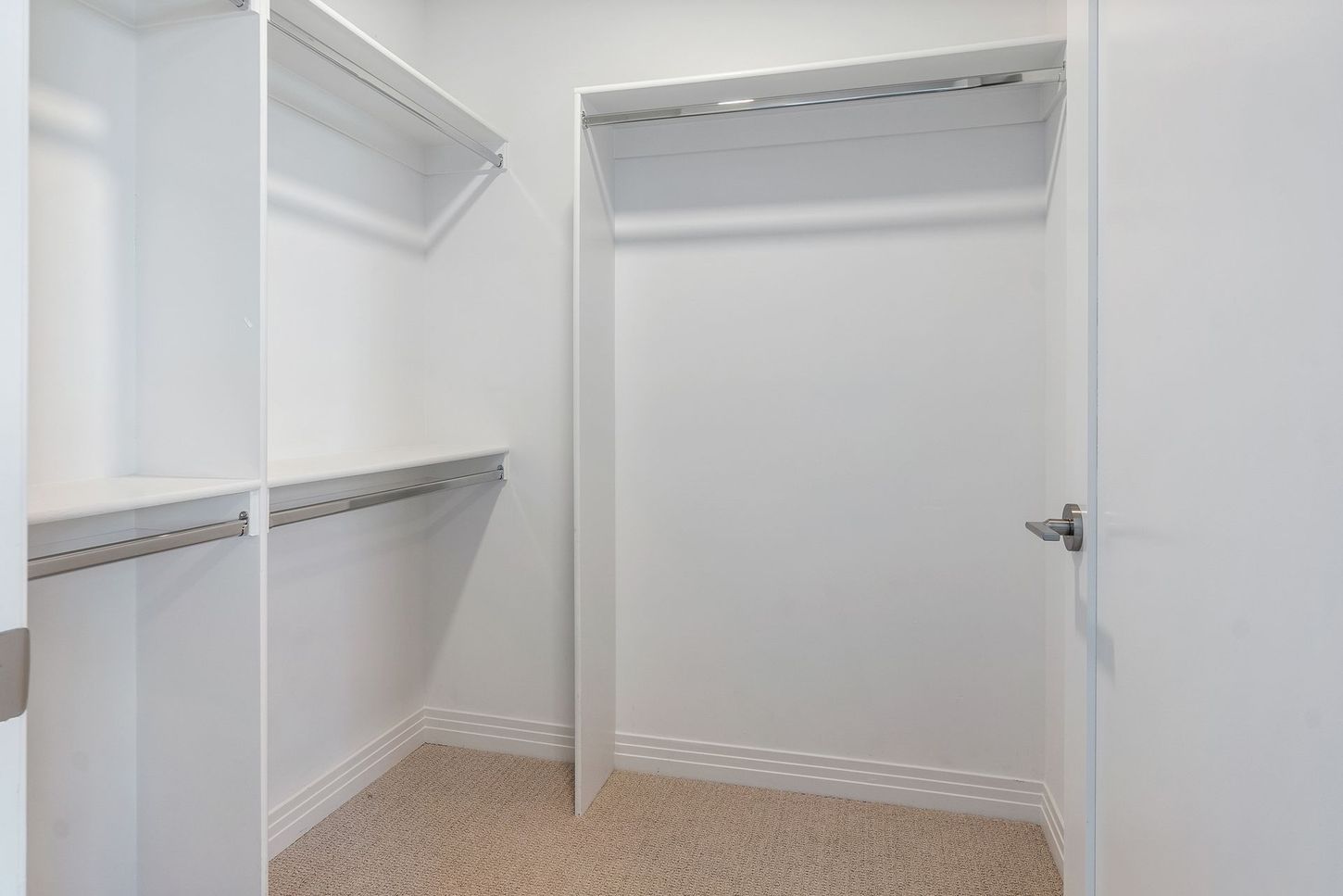 A walk in closet with a door and shelves in a house.