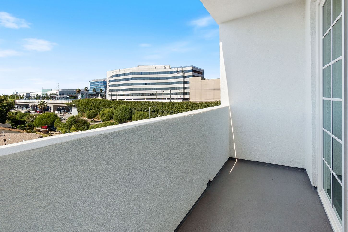 A balcony with a view of a building and trees