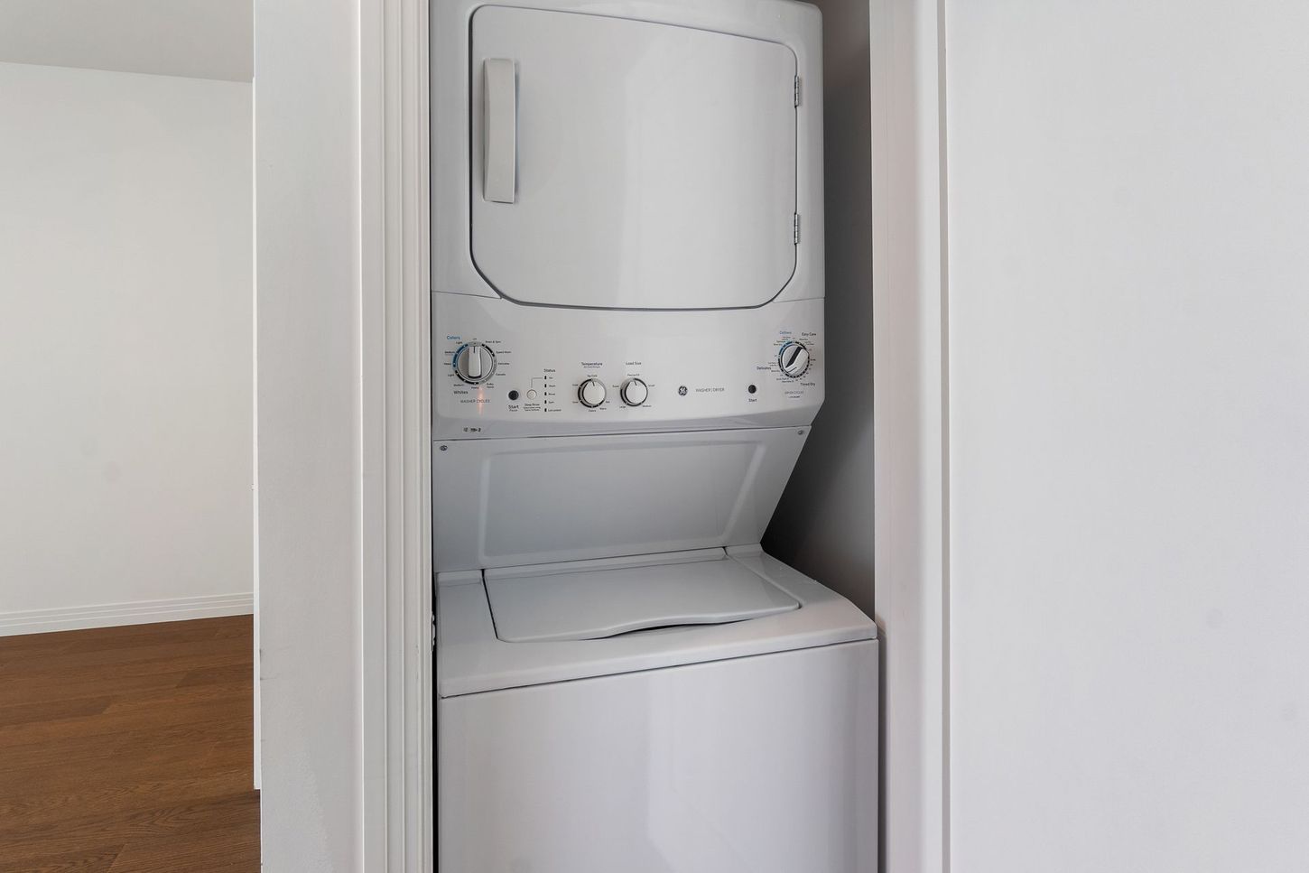 A washer and dryer are stacked on top of each other in a closet.