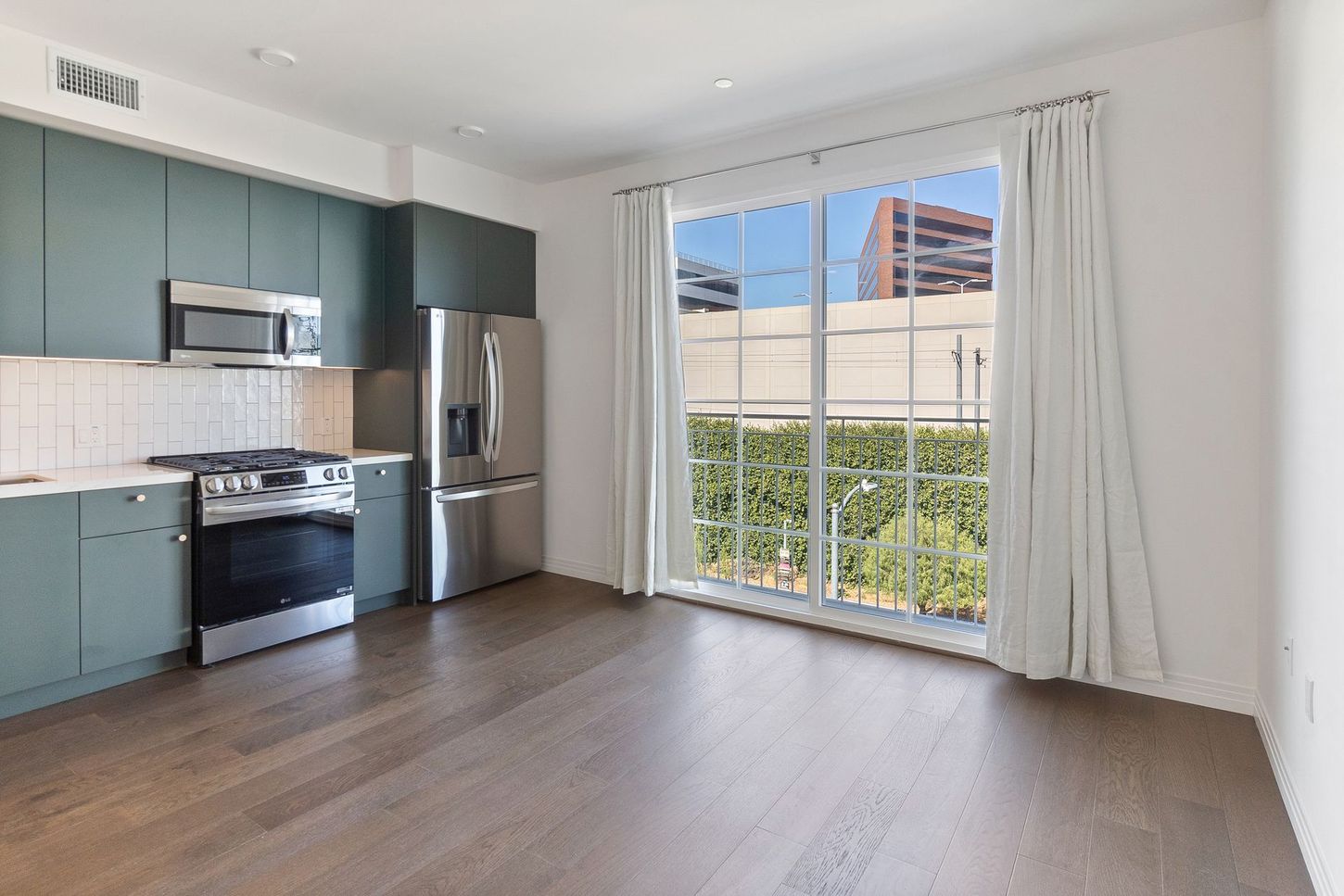 A kitchen with stainless steel appliances and a large window