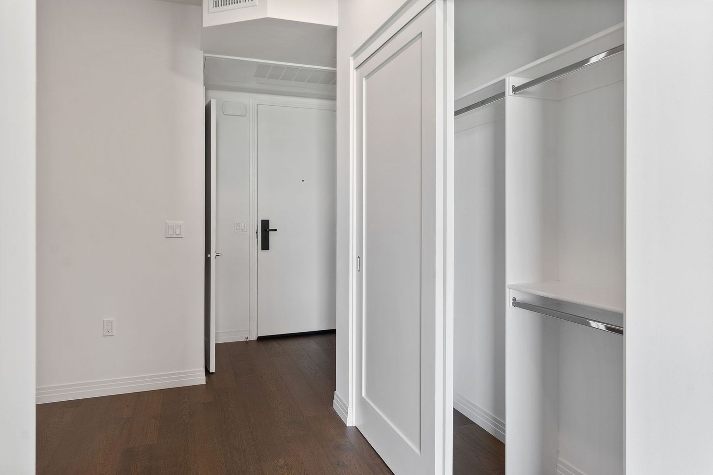 A hallway with a closet and a door in a house.